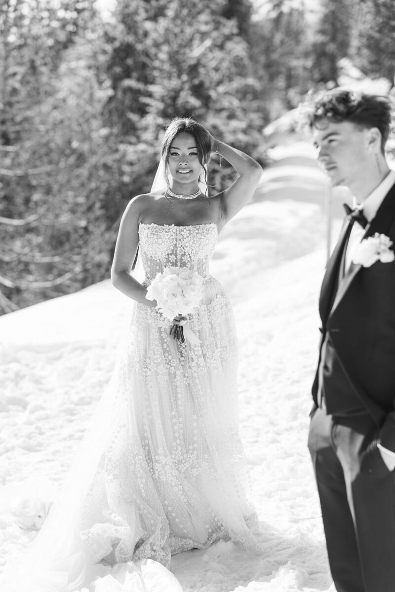 Jeune mariée en robe travaillée s'approchant de son futur mari lors de son mariage en montagne enneigée Jeune mariée en robe travaillée s'approchant de son futur mari - Raja Agency