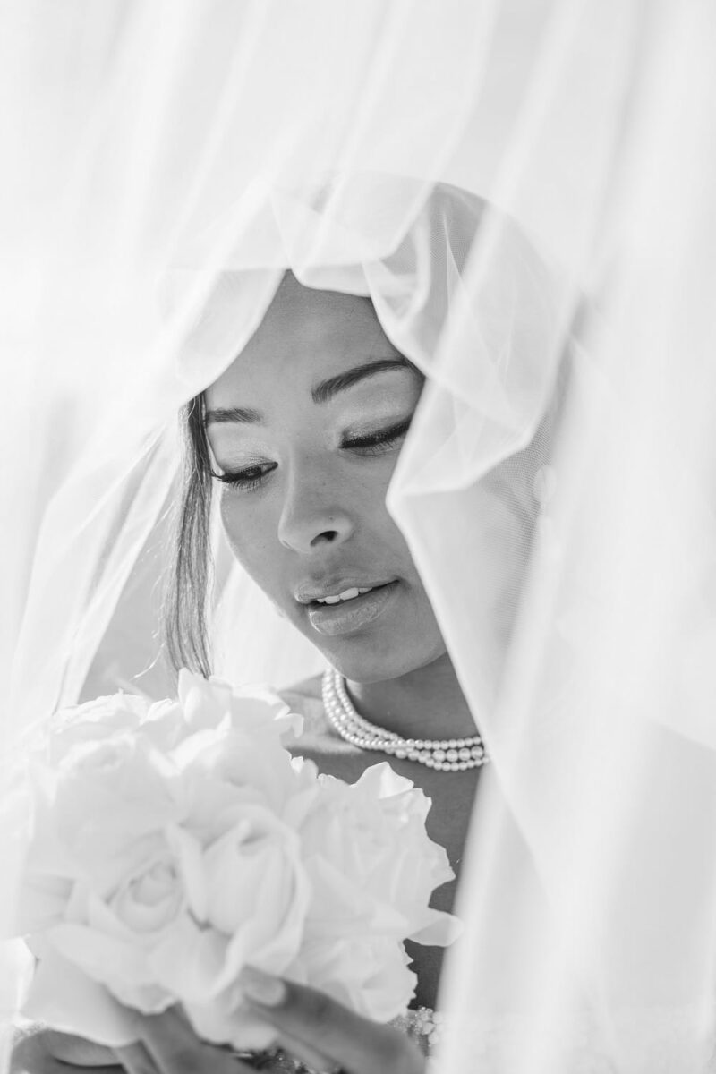 Close-up sur le visage d'une jeune mariée, regardant son bouquet de roses Close-up sur le visage d'une jeune mariée - Raja Agency