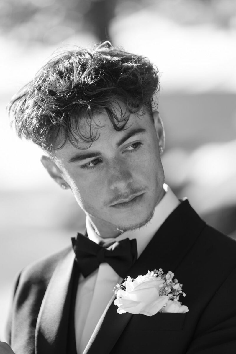 Futur marié regardant derrière lui pour voir arriver sa fiancée, il a une boutonnière en rose blanche Futur marié regardant derrière lui pour voir arriver sa fiancée - Raja Agency